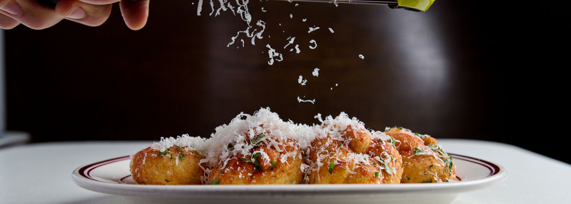 grating parmesan on an entree
