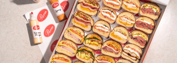 a box of sandwiches and sauces on the side